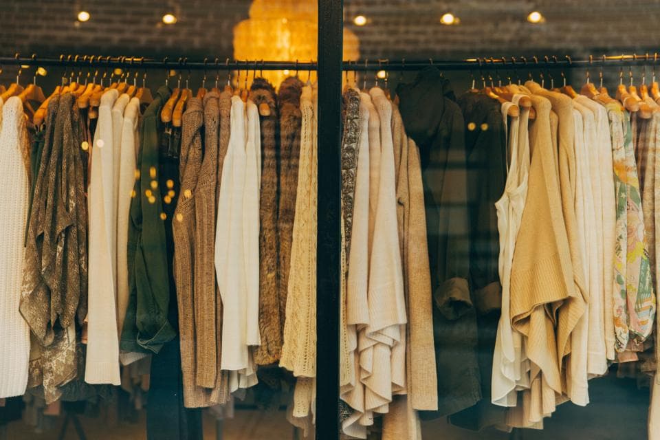 Rows of clothing hanging in a boutique retail store